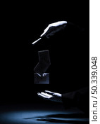 magician performing trick with magic wand against black background. Стоковое фото, агентство Ingram Publishing / Фотобанк Лори