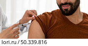 doctor vaccinating bearded man. Стоковое фото, агентство Ingram Publishing / Фотобанк Лори