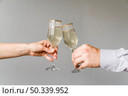 friends hands clinking glasses champagne grey background. Стоковое фото, агентство Ingram Publishing / Фотобанк Лори
