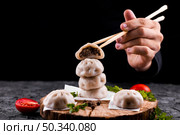 hand holding chopsticks with dumpling. Стоковое фото, агентство Ingram Publishing / Фотобанк Лори