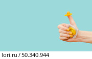 woman holding yellow condom her finger. Стоковое фото, агентство Ingram Publishing / Фотобанк Лори