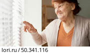 close up woman looking out window. Стоковое фото, агентство Ingram Publishing / Фотобанк Лори