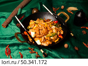 Stir Fried Pork Dish Presented in a Wok on Green Velvet. Стоковое фото, фотограф Aleksandr Golubev / Фотобанк Лори