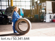 little girl overall standing with car wheel. Стоковое фото, агентство Ingram Publishing / Фотобанк Лори