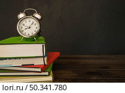 alarm clock with books pile desk. Стоковое фото, агентство Ingram Publishing / Фотобанк Лори