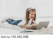school girl wearing headphones attending online classes. Стоковое фото, агентство Ingram Publishing / Фотобанк Лори