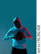 young man playing basketball alone with cool lights. Стоковое фото, агентство Ingram Publishing / Фотобанк Лори