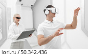 young man with virtual reality simulator woman testing. Стоковое фото, агентство Ingram Publishing / Фотобанк Лори