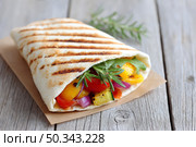 Grilled vegetable wrap with fresh rosemary on rustic wood table. Стоковое AI-изображение, AI-художник Мария Фадеева / Фотобанк Лори