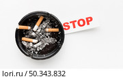 ashtray with smoked cigarettes stop habit message. Стоковое фото, агентство Ingram Publishing / Фотобанк Лори