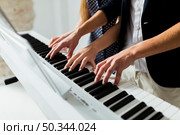 close up couple s hand playing piano keyboard. Стоковое фото, агентство Ingram Publishing / Фотобанк Лори