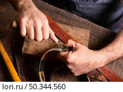 handyman working leather belt. Стоковое фото, агентство Ingram Publishing / Фотобанк Лори