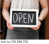 man holding we are open sign. Стоковое фото, агентство Ingram Publishing / Фотобанк Лори