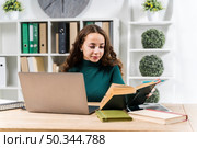 medium shot smiley girl studying with dictionary laptop. Стоковое фото, агентство Ingram Publishing / Фотобанк Лори