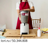 midsection view woman grinding paper pulp mixer. Стоковое фото, агентство Ingram Publishing / Фотобанк Лори