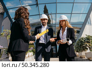 three architects talking front glass buidling. Стоковое фото, агентство Ingram Publishing / Фотобанк Лори