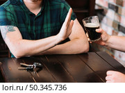 man refusing glass rum offered by his friend. Стоковое фото, агентство Ingram Publishing / Фотобанк Лори