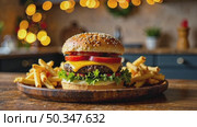 Delicious burger and French fries in home kitchen with Christmas decor, lights of garland. Delivery from fast food restaurant, menu burger home cooking for New year. AI generated; Стоковое AI-видео, аниматор Ольга Симонова / Фотобанк Лори