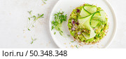 Vegan open sandwich with dietary crispbread, fresh cucumber, onion, sesame seed, microgreens and avocado. Healthy vegetarian food, diet. Top view. Banner. Стоковое фото, агентство Ingram Publishing / Фотобанк Лори