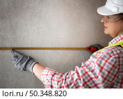 side view female construction worker with helmet tape measurer. Стоковое фото, агентство Ingram Publishing / Фотобанк Лори