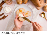 top view woman spreading cream cheese bread. Стоковое фото, агентство Ingram Publishing / Фотобанк Лори