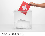 person putting switzerland flag card into ballot box. Стоковое фото, агентство Ingram Publishing / Фотобанк Лори