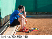 sideways kid sitting after game. Стоковое фото, агентство Ingram Publishing / Фотобанк Лори