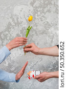 woman s hand accepting yellow tulip rejecting pocket cigarette from man. Стоковое фото, агентство Ingram Publishing / Фотобанк Лори