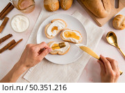 flat lay woman spreading cream cheese bread. Стоковое фото, агентство Ingram Publishing / Фотобанк Лори