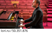 side view man playing classical piano recital. Стоковое фото, агентство Ingram Publishing / Фотобанк Лори