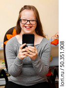 smiley girl with down syndrome holding phone. Стоковое фото, агентство Ingram Publishing / Фотобанк Лори