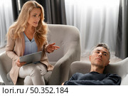 woman therapist talking man laying couch. Стоковое фото, агентство Ingram Publishing / Фотобанк Лори