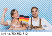 bavarian friends holding german flag. Стоковое фото, агентство Ingram Publishing / Фотобанк Лори