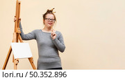 front view girl down syndrome posing easel. Стоковое фото, агентство Ingram Publishing / Фотобанк Лори