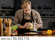 mid shot chef grating cheese. Стоковое фото, агентство Ingram Publishing / Фотобанк Лори