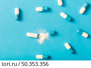 split open capsule with white powder blue background. Стоковое фото, агентство Ingram Publishing / Фотобанк Лори