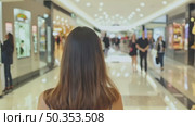 Woman with long brown hair, seen from behind, walks through a bright modern shopping mall, capturing the essence of retail therapy or urban lifestyle. Стоковое AI-видео, аниматор Елена Никишина / Фотобанк Лори