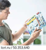 young man looking motherboard circuit. Стоковое фото, агентство Ingram Publishing / Фотобанк Лори