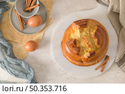 Fogaca on kitchen countertop with eggs and cinammon sticks. Traditional cake from Santa Maria da Feira, Portugal. Стоковое фото, агентство Ingram Publishing / Фотобанк Лори