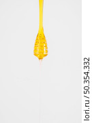 close up honey dripping from dipper white background. Стоковое фото, агентство Ingram Publishing / Фотобанк Лори