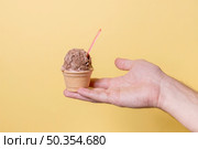hand holding little ice cream chocolate scoop. Стоковое фото, агентство Ingram Publishing / Фотобанк Лори