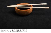 chopsticks soya sauce wooden bowl black backdrop. Стоковое фото, агентство Ingram Publishing / Фотобанк Лори