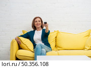 elderly woman changing television channels. Стоковое фото, агентство Ingram Publishing / Фотобанк Лори
