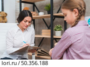 female psychologist taking notes clipboard therapy session. Стоковое фото, агентство Ingram Publishing / Фотобанк Лори