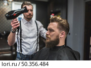 hairdresser using drier hair client. Стоковое фото, агентство Ingram Publishing / Фотобанк Лори