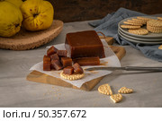Marmalade in crackers on a kitchen counter with quinces on a cork tray. Стоковое фото, агентство Ingram Publishing / Фотобанк Лори