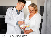 front view doctor showing model spine. Стоковое фото, агентство Ingram Publishing / Фотобанк Лори