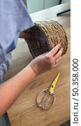 Woman reviewing souvenir wicker storage basket. Vertical video. Стоковое видео, видеограф Vadzim Yakubovich / Фотобанк Лори