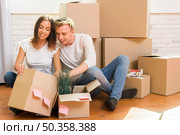 couple sitting floor inspect box. Стоковое фото, агентство Ingram Publishing / Фотобанк Лори