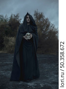 long portrait man dressed as dark mage with skull. Стоковое фото, агентство Ingram Publishing / Фотобанк Лори